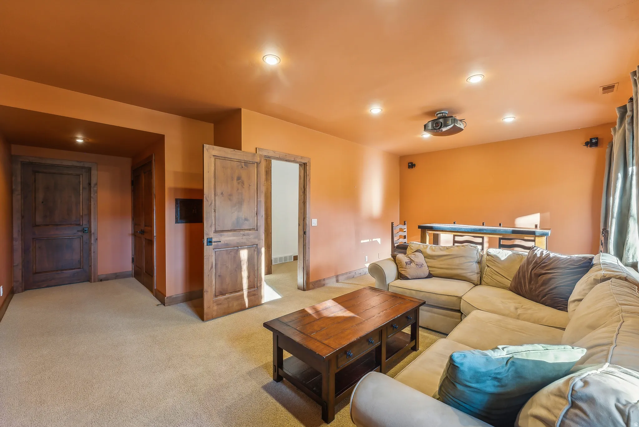 Media room featuring recessed lighting, a ceiling-mounted projector, and integrated wall speakers