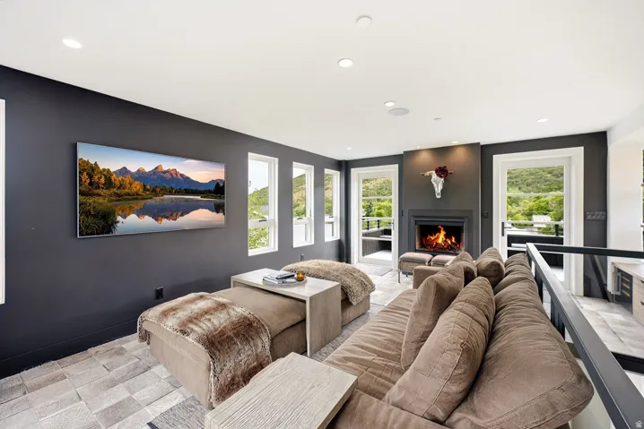 Living area featuring a dark accent wall, recessed lighting, and a fireplace with a dark mantel