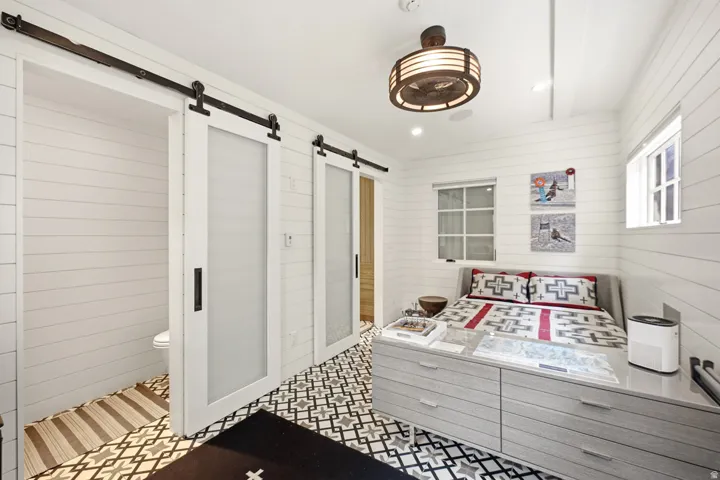 Interior space featuring white shiplap walls and patterned floor tiles