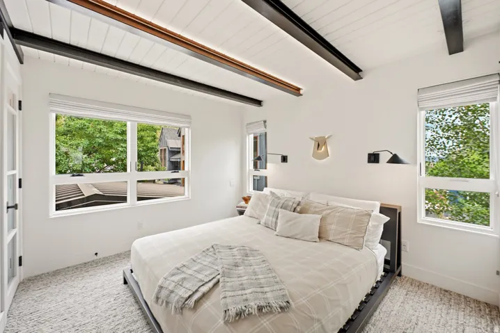 Vaulted ceiling with exposed beams and recessed lighting