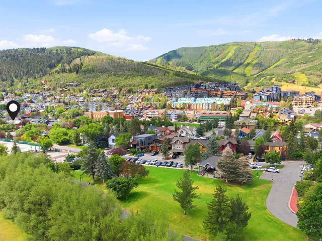Townscape with varying architectural styles, green spaces, and mountainous backdrops