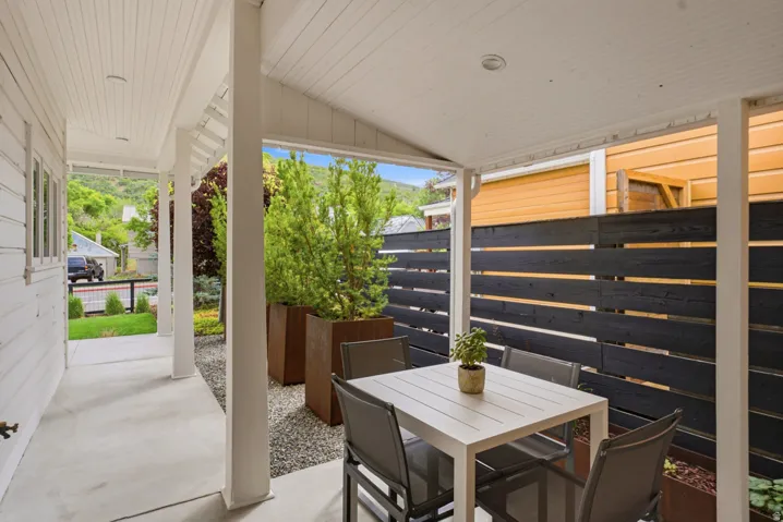 Covered concrete patio with white plank ceiling, recessed lighting, and white support columns