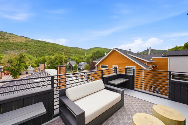 Rooftop deck featuring a metal railing, built-in counter space, and a neutral-toned patterned outdoor rug