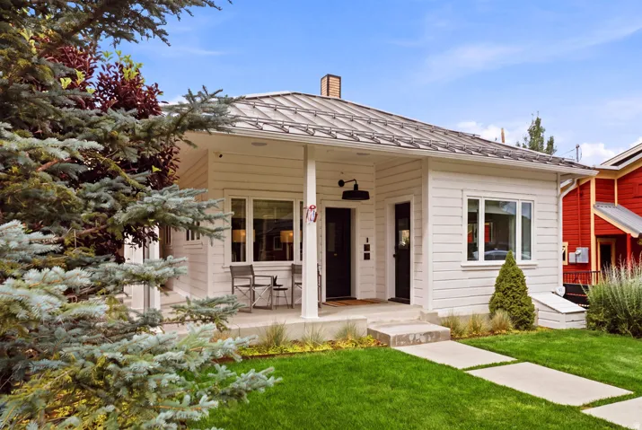 White horizontal siding exterior with a metal roof and covered front porch