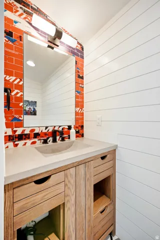Powder room featuring a custom wood vanity with integrated sink, concrete countertop, and matte black faucet