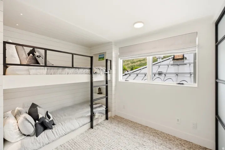 Custom built-in bunk beds with matte black metal framing and white shiplap wall paneling