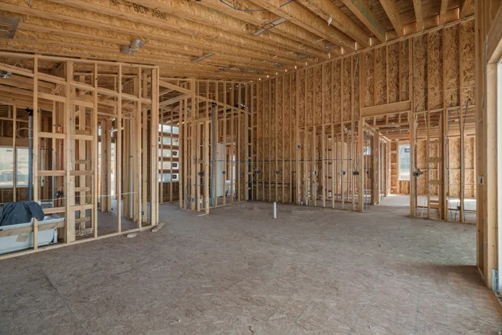Unfinished interior framing with exposed wood beams and subflooring