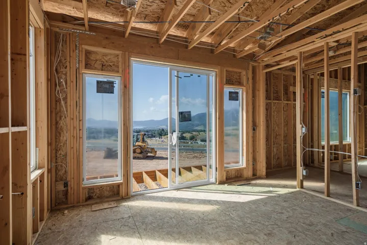 New construction framing with exposed wooden studs and ceiling joists
