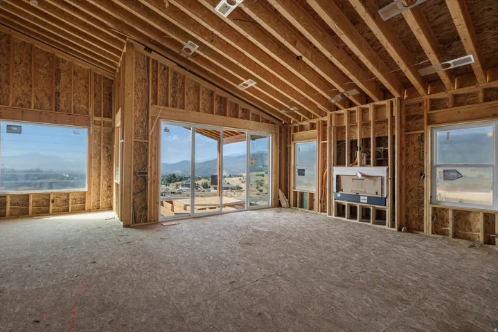 Expansive interior framing featuring a vaulted ceiling and exposed wood beams