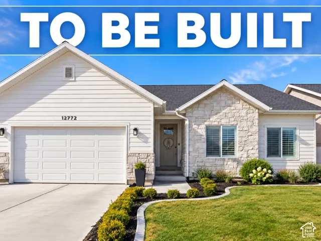 White horizontal siding, stone veneer accents, integrated garage, concrete driveway, and landscaped front yard