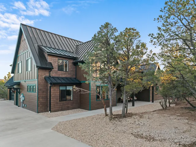 Contemporary home featuring a gabled metal roof, horizontal wood siding, and vertical board and batten accents