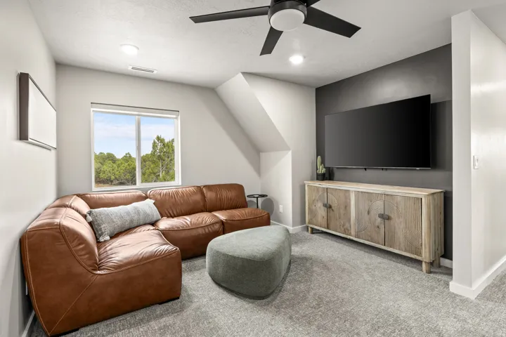 Carpeted room featuring a ceiling fan, recessed lighting, and a window with outdoor scenery