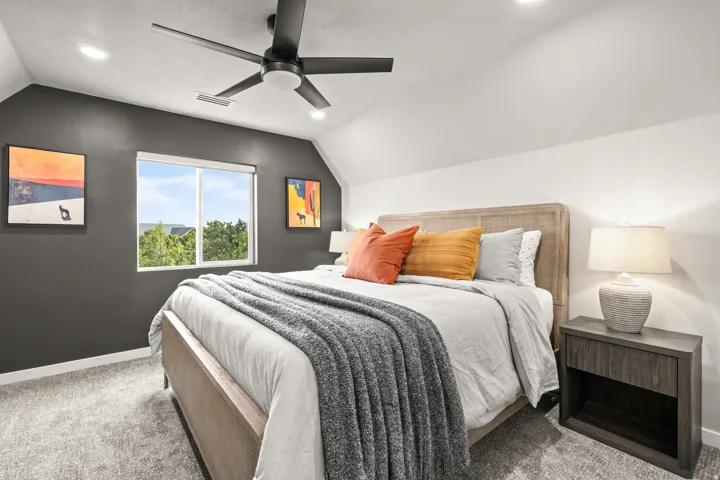 Carpeted room featuring a modern ceiling fan with integrated lighting, recessed overhead lighting, and a window providing natural illumination