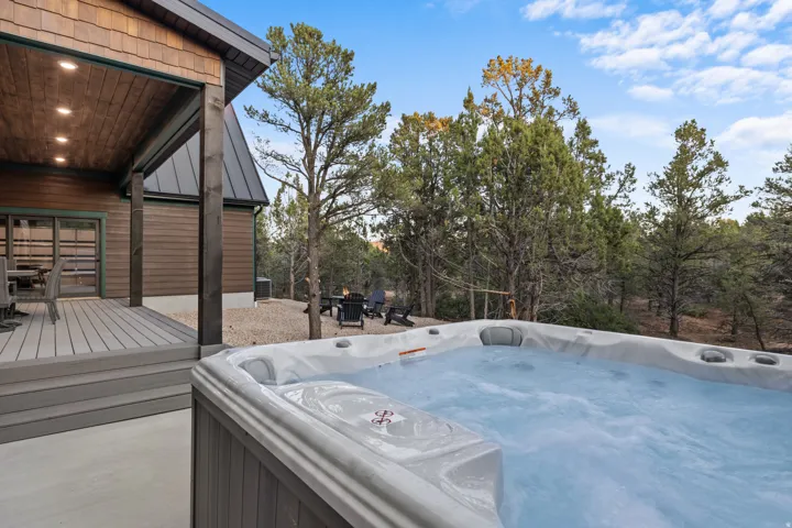 Outdoor spa with a covered deck, wood-paneled ceiling, recessed lighting, and a composite deck surface