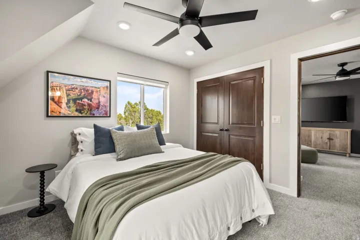 Carpeted room with a vaulted ceiling, recessed lighting, and a contemporary ceiling fan