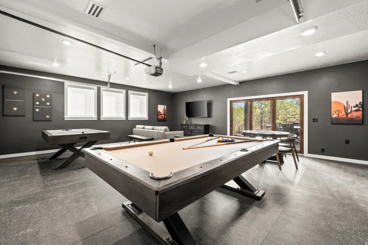 Spacious recreation room featuring dark walls, recessed lighting, and durable flooring