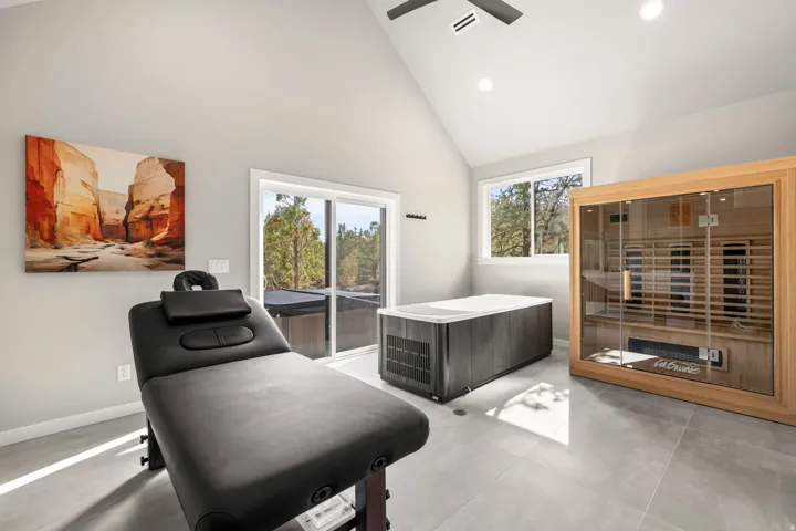 Vaulted ceiling room featuring a built-in hot tub, a wooden sauna, recessed lighting, and large windows