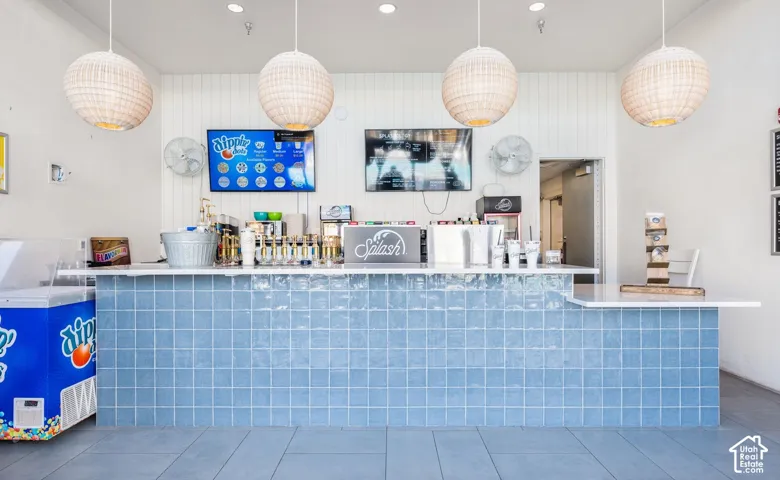 Commercial counter space featuring blue square tile facade and white countertop