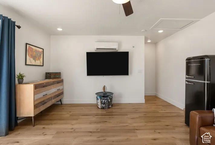Living area featuring light wood-finish flooring and a white ceiling with recessed lighting