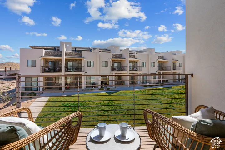 Private balcony with metal railing overlooking a landscaped lawn