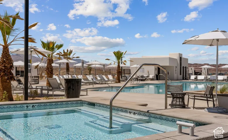 Community pool area featuring a spa, multiple swimming pools, and a sun deck with lounge chairs