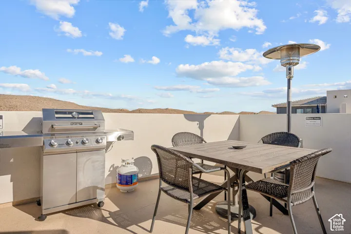 Rooftop patio featuring a stainless steel grill, exterior privacy walls, and expansive mountain scenery