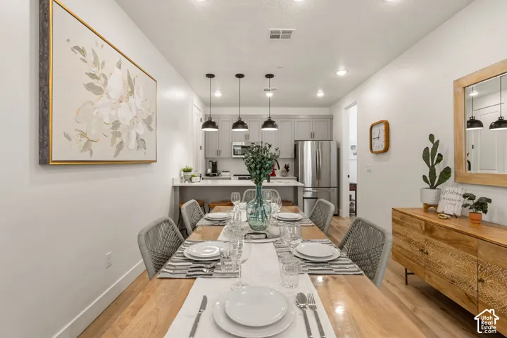 Open-concept dining area featuring wood-finish flooring, recessed lighting, and a neutral color palette