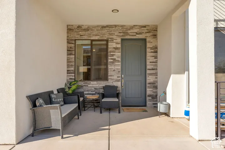 Covered entry featuring a gray paneled door and stacked stone accent wall
