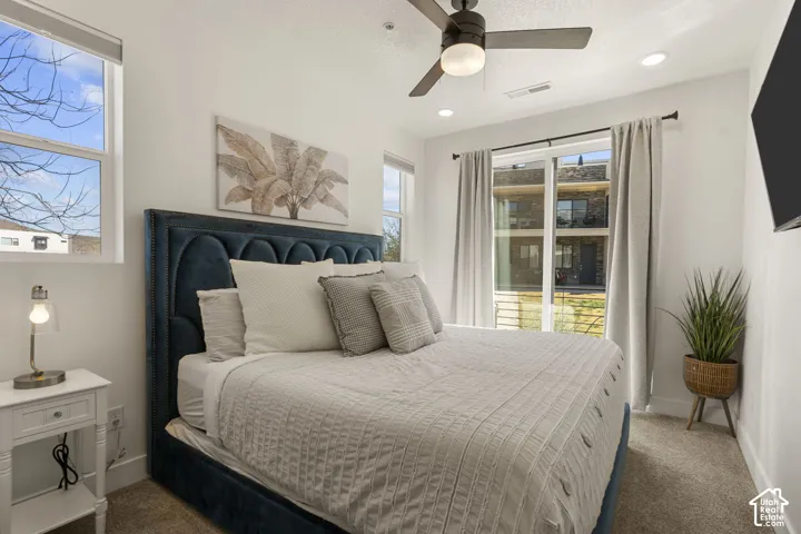 Bedroom featuring a large window, sliding glass door, recessed lighting, and a ceiling fan