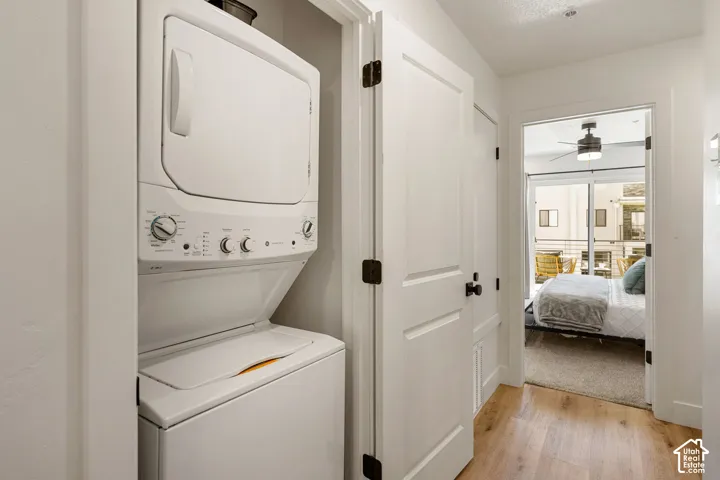 Dedicated laundry closet featuring a stacked white washer and dryer unit