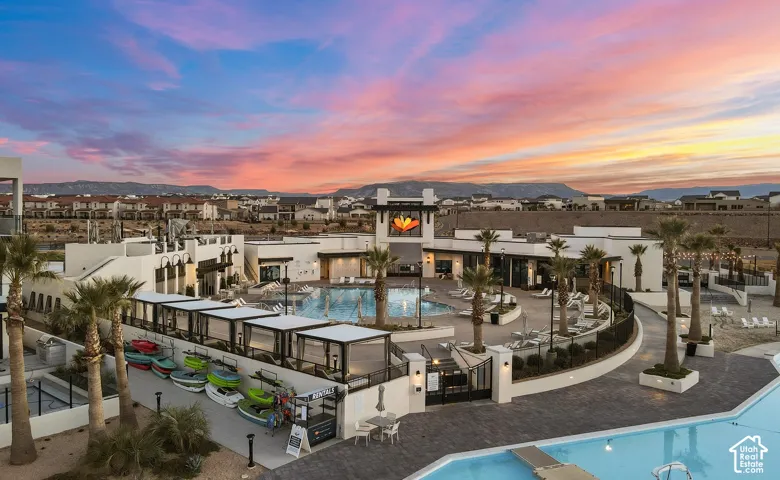 Expansive community amenity area featuring multiple swimming pools, extensive lounge seating, private cabanas, and integrated recreational equipment storage