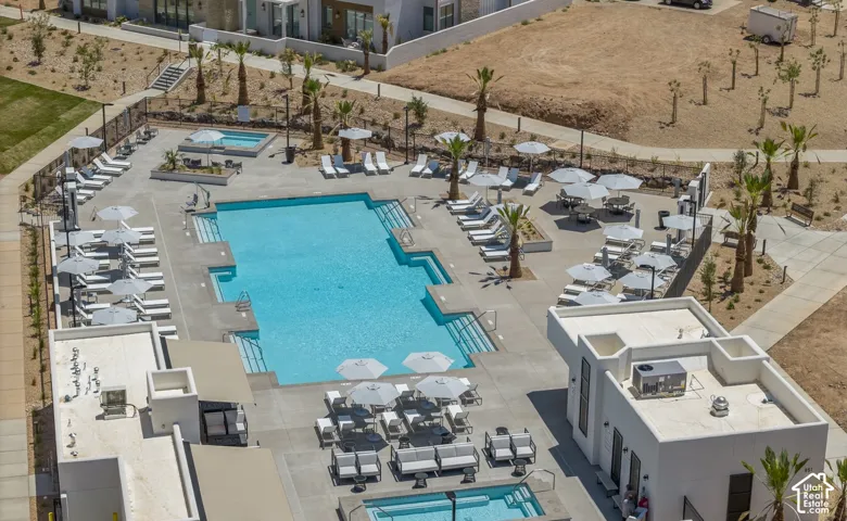 Expansive pool area featuring a large swimming pool, an additional smaller pool, and a surrounding concrete deck