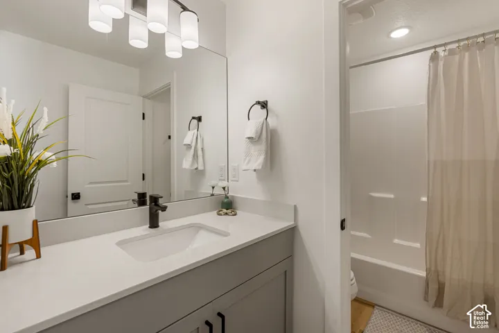 Modern bathroom featuring a single vanity with a light-toned countertop, integrated sink, and matte black faucet