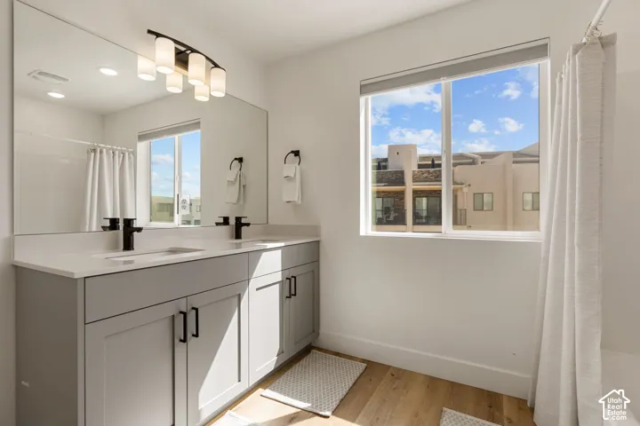 Dual vanity with light gray cabinetry, matte black fixtures, and a white countertop