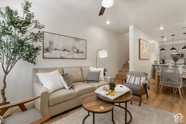 Open-concept living area featuring wood-finish flooring, recessed lighting, and a ceiling fan