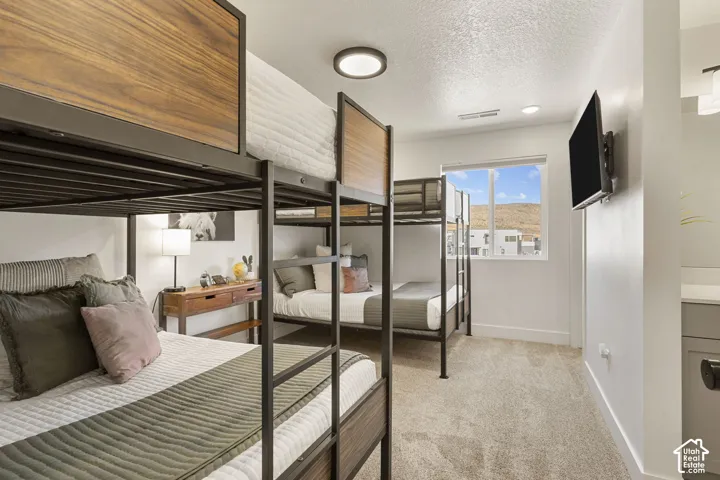 Carpeted room featuring two bunk beds with wood-finish panels and metal frames