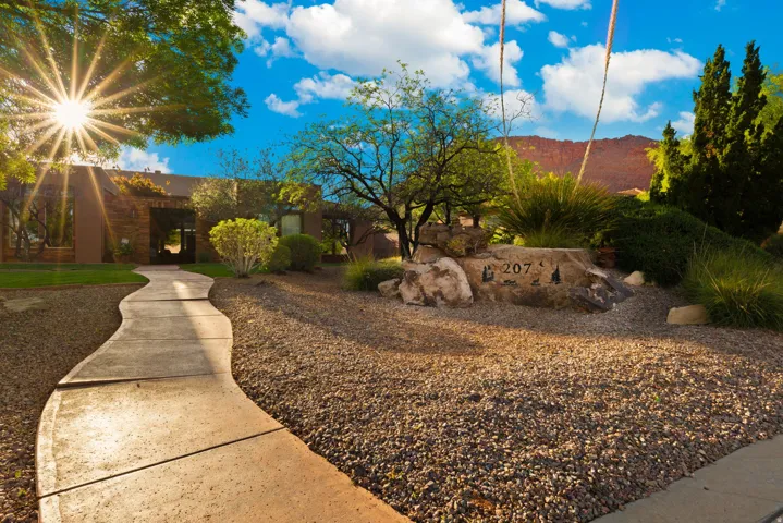 Winding concrete pathway leading to the property entrance