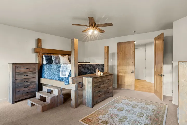 Room featuring a ceiling fan with integrated lighting, two panel-style wood doors, and light-toned wall finishes