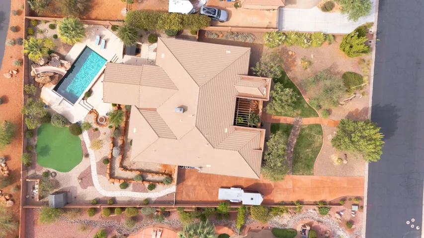 Expansive property featuring a swimming pool, artificial turf putting green, mature desert landscaping, and a covered patio area