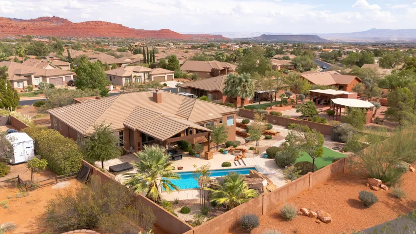 Expansive property featuring a swimming pool, integrated hot tub, covered patio, and desert landscaping