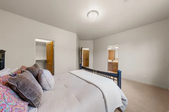 Bedroom featuring neutral wall colors, carpet flooring, a ceiling-mounted light fixture, and natural wood doors
