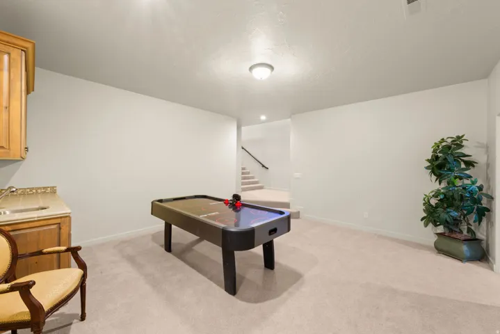 Lower-level recreation space featuring neutral carpeting and light-toned walls