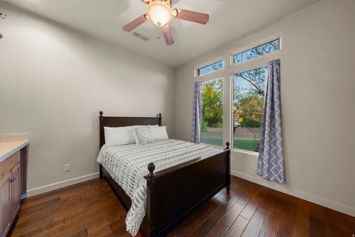 Bright interior featuring wood-finish flooring, a neutral wall color, and a ceiling fan with integrated lighting