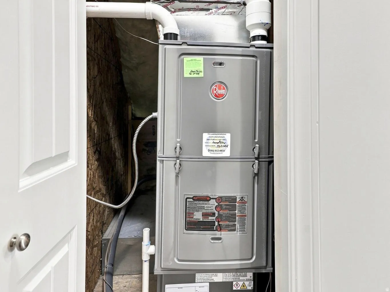 Rheem HVAC system located within a utility closet, featuring visible ductwork and associated piping