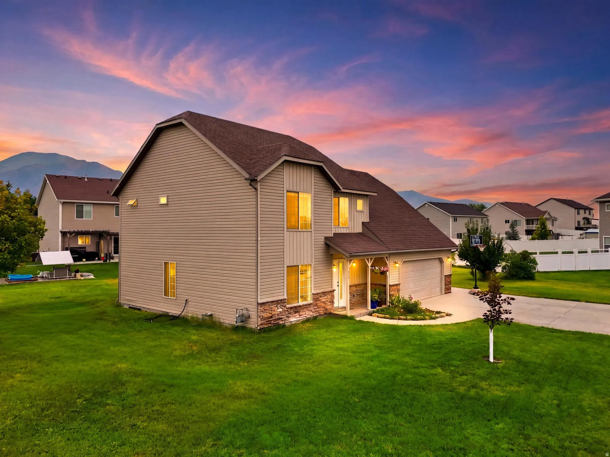 Two-story residence featuring light-colored siding and stone accents