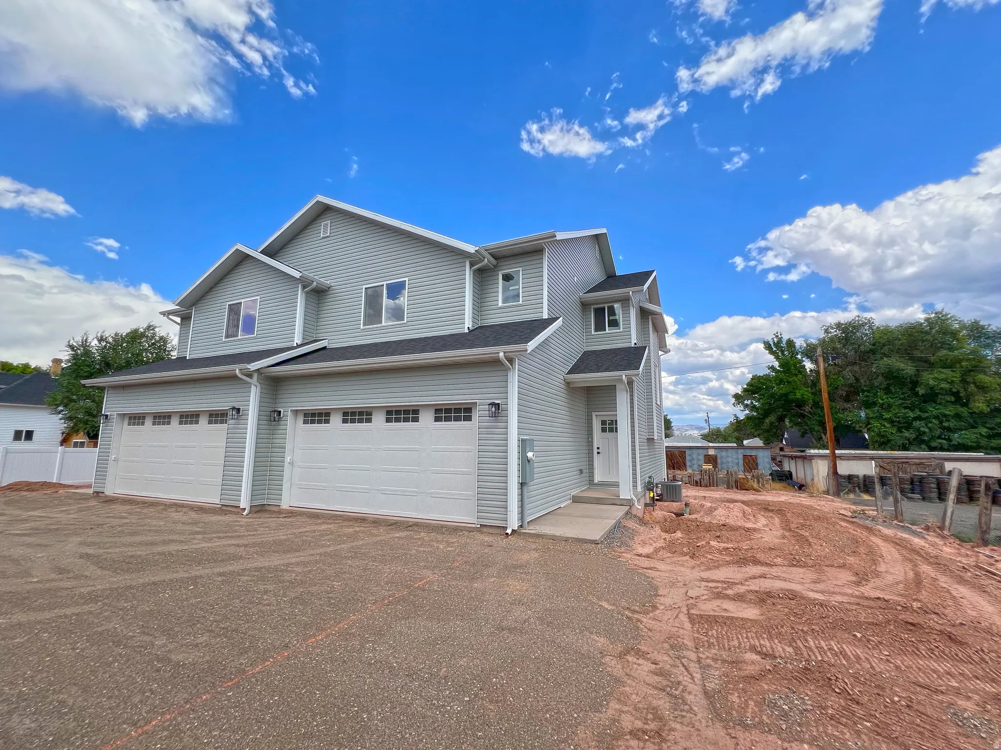 Contemporary multi-level residence featuring light gray siding and white trim