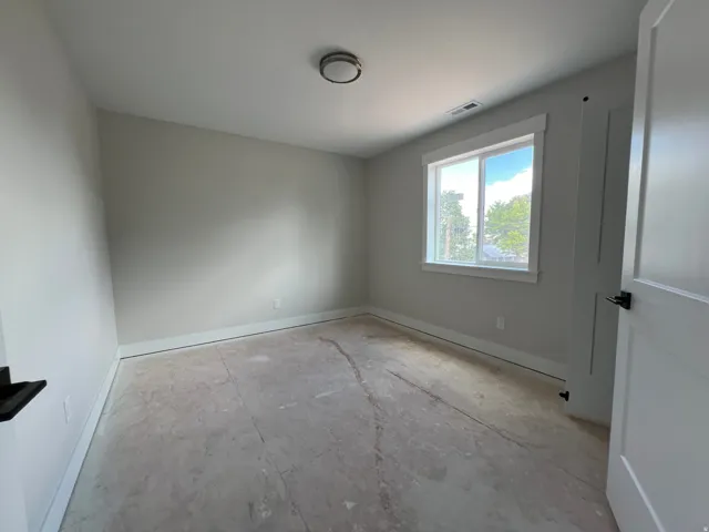 Bright interior space featuring a double-pane window, white trim throughout, and a flush-mount ceiling light