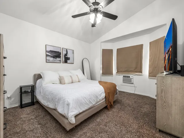 Spacious room with vaulted ceilings and a ceiling fan