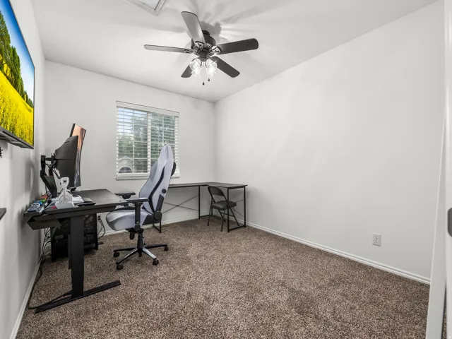 Bedroom featuring neutral-toned carpeting, a ceiling fan with integrated lighting, a single window with blinds, and white walls