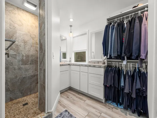 Corner vanity with dual mirrors, integrated sink, and white cabinetry